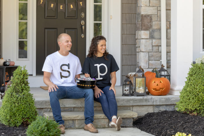 Two people sitting on steps wearing shirts that have S and P on them