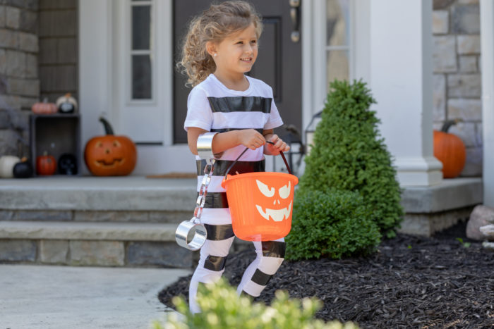 A child dressed a striped Halloween prison's costume.