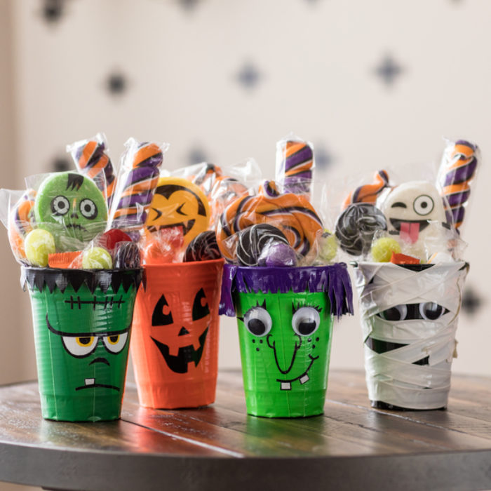 Four cups decorated as monsters with Duck Tape.