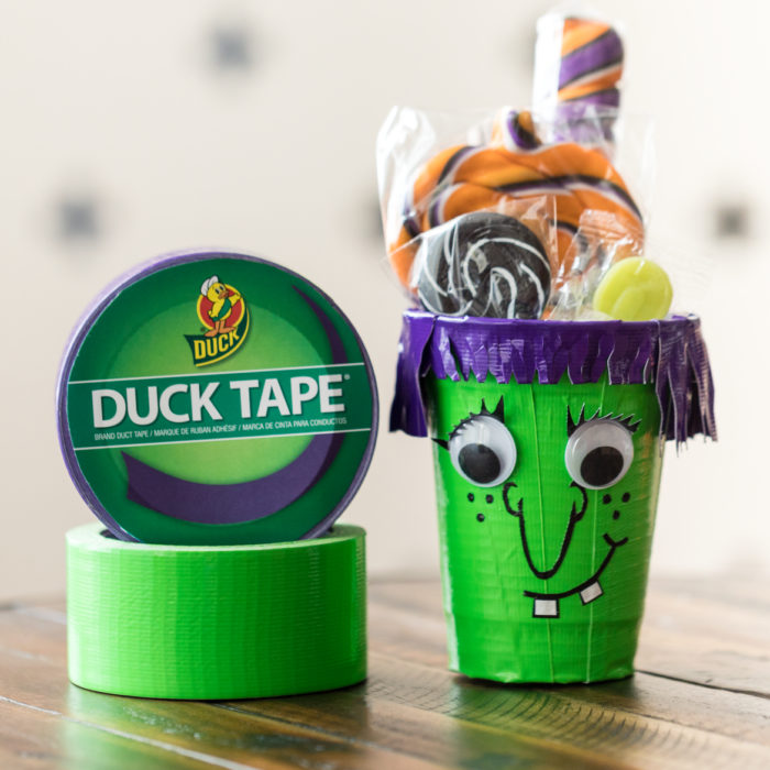 Plastic cup decorated for Halloween with purple and green Duck Tape
