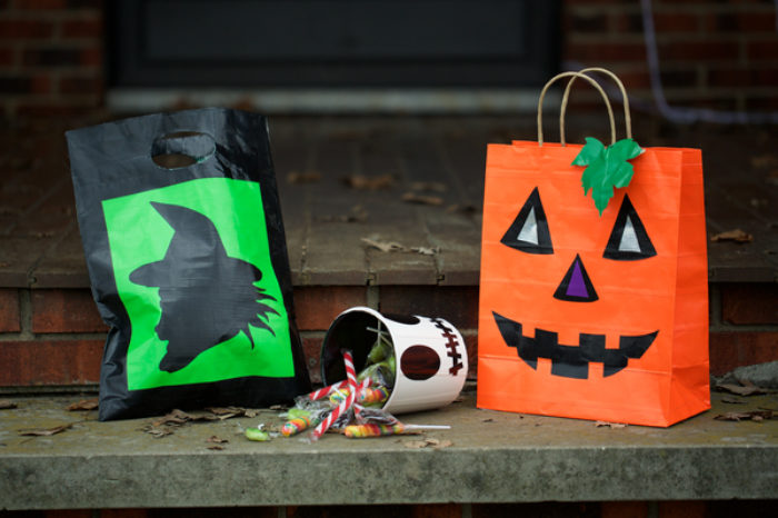 A trick or treat candy bag decorated as a jack-o-lantern.