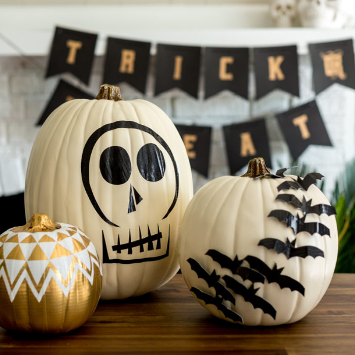 White plastic pumpkins decorated with black Duck Tape.