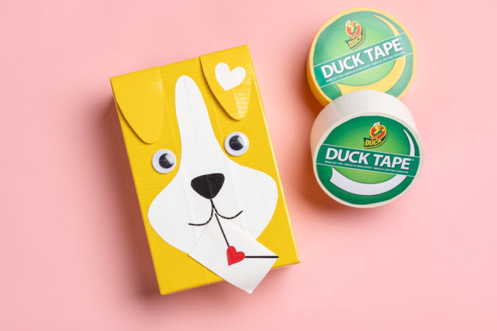A Valentine's day card box decorated as a dog with yellow Duck Tape.