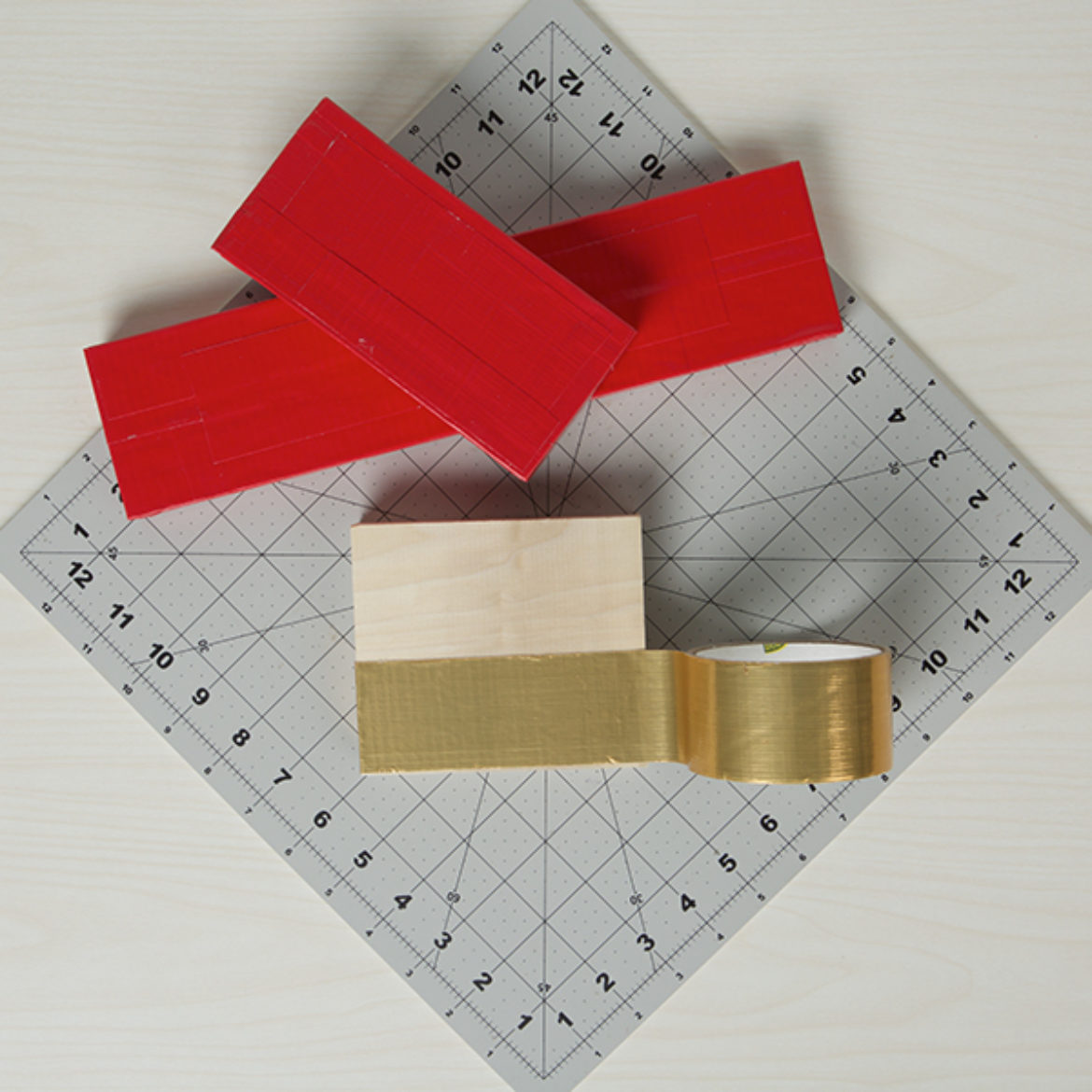 Three blocks covered in red and gold colored Duck Tape