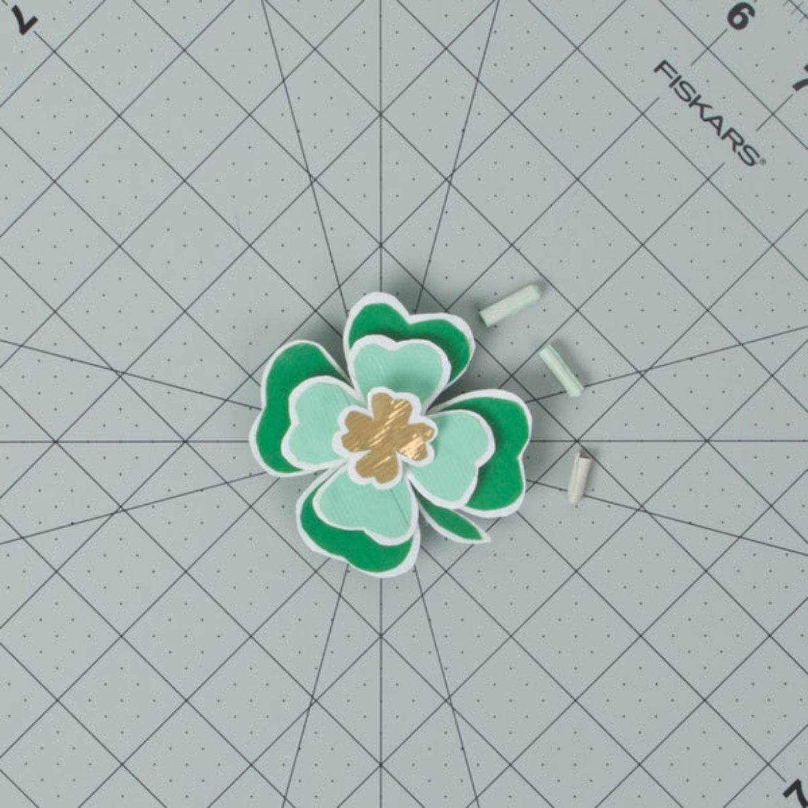 Tape the medium sized clover the the larger one, then tape the smallest clover to the medium clover. Tape a magnet to the back of the clover