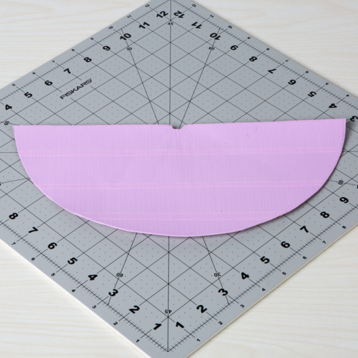 double sided Duck Tape fabric cut into a half circle shape with a small notch cut into the center of the flat side