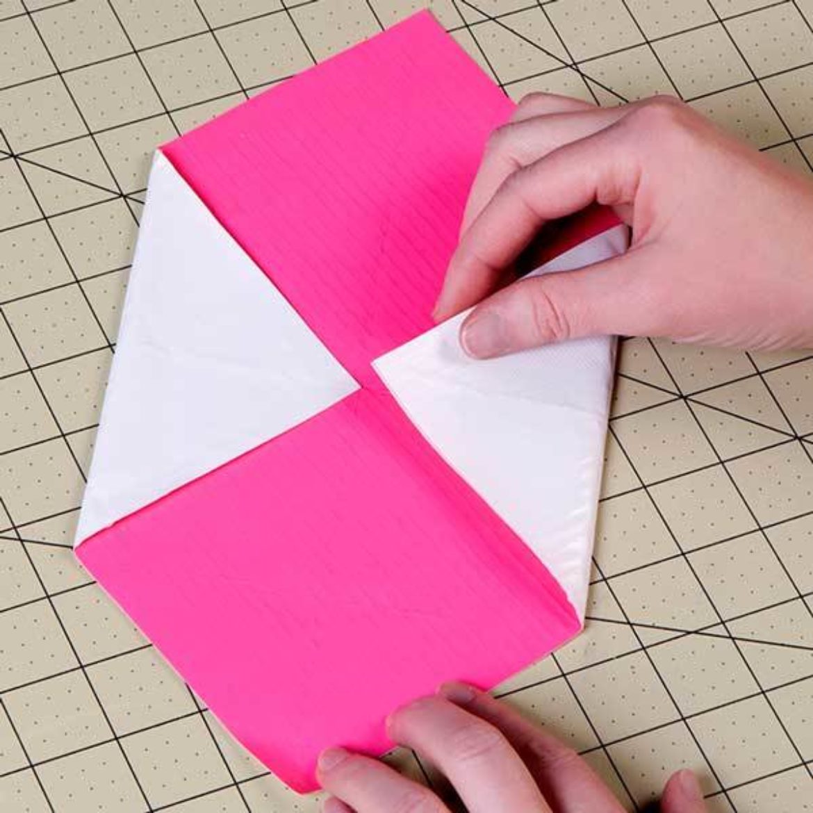 Four corners of the square folded to the center to form a smaller square shape