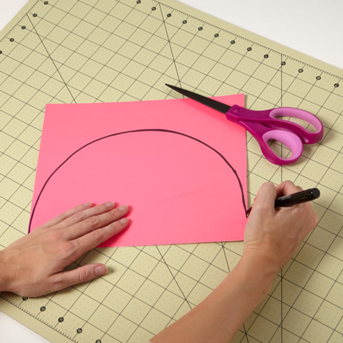 Half circle being drawn on a pink sheet of Duck Tape fabric