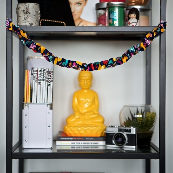 Completed Duck Tape® Garland hanging from a book shelf