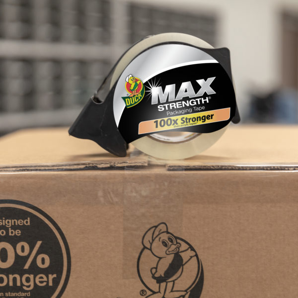 Duck Max Strength Packaging Tape in dispenser sitting on top of sealed brown corrugate box