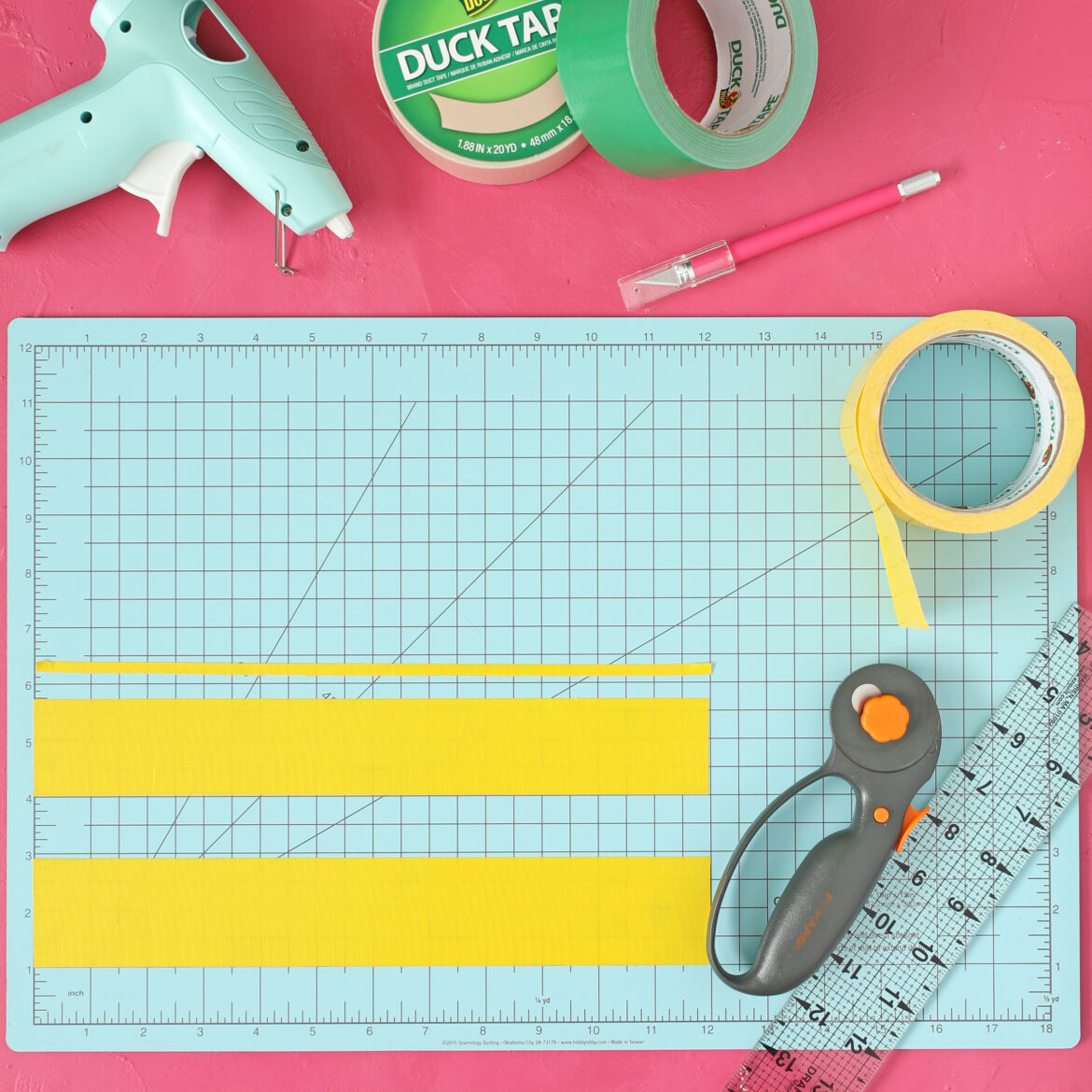 Two strips of yellow Duck Tape with crafting supplies.
