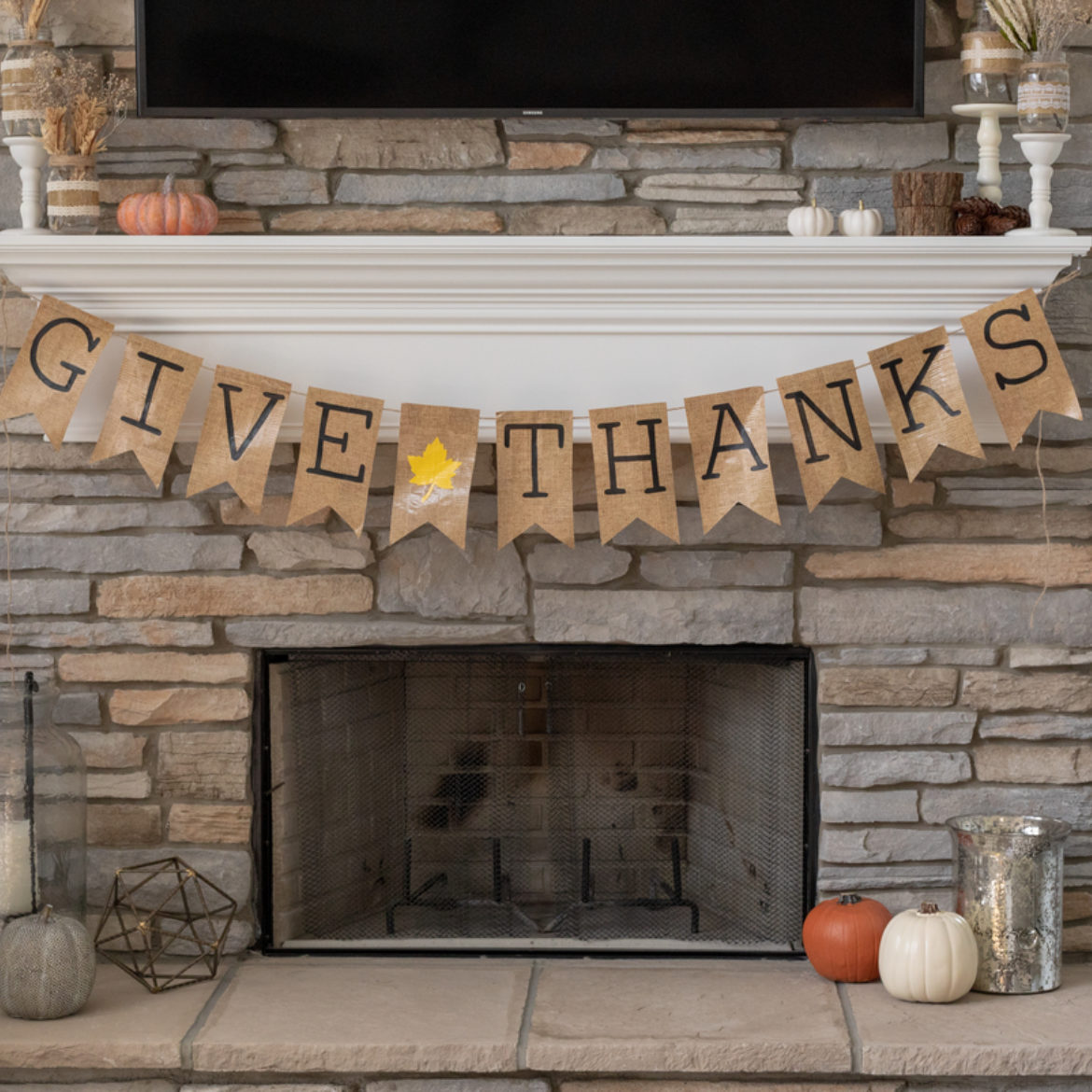 Completed Give Thanks Banner hanging from a mantle