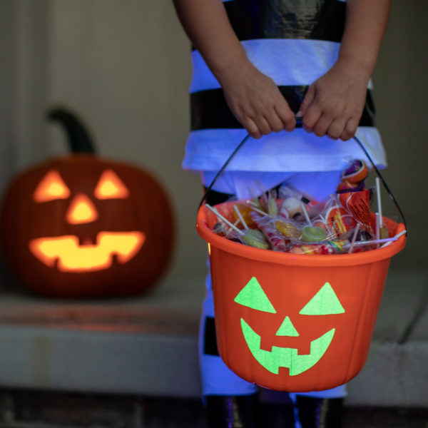 Child holding a completed Glow-in-the-Dark Pumpkin Treat Bucket