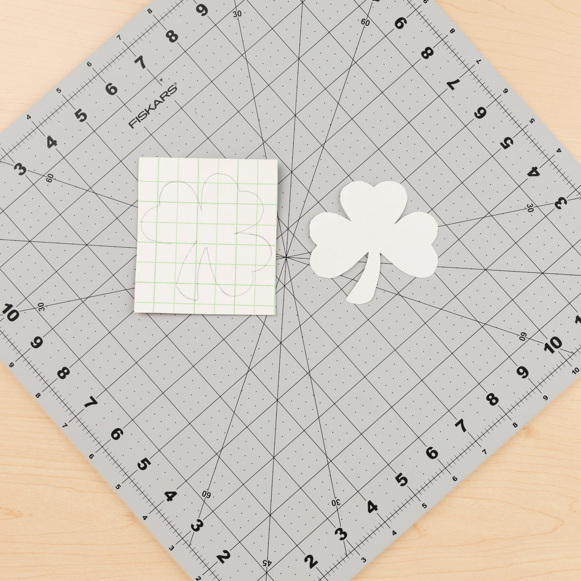 Shamrock template made with construction paper. Shamrock traced onto Duck Tape fabric made in step one