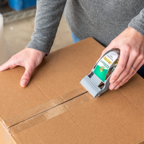 Woman using One-Handed EZ Start Dispenser to seal a brown corrugate box