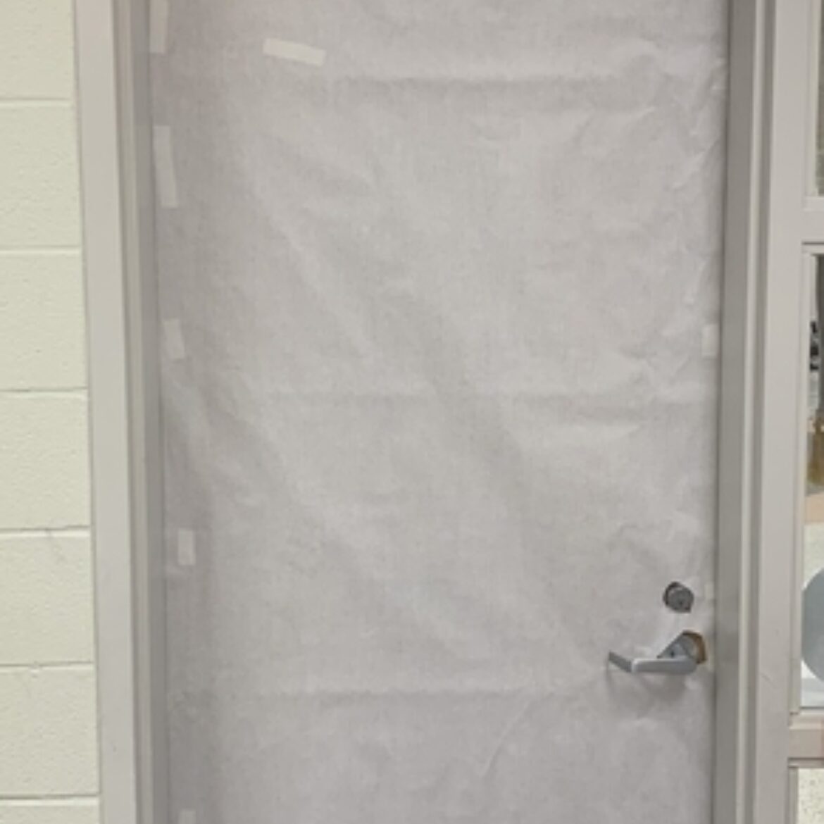 Classroom door wrapped with white paper