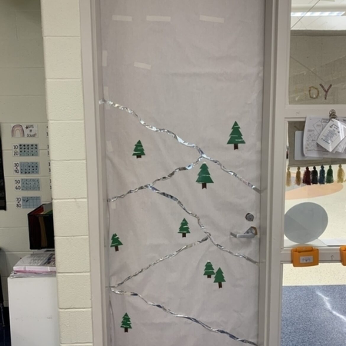 Classroom door with white paper, silver lines to look like mountain tops and pine trees