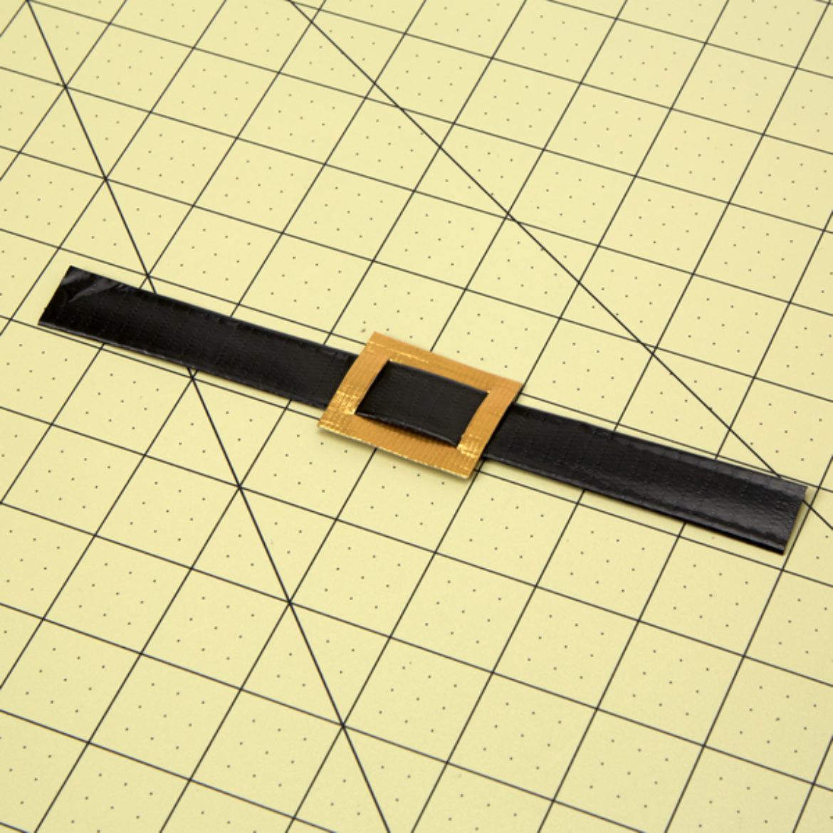 Cut two slits into the previous gold rectangle and feed the strap through to form a buckle and strap
